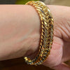 Close-up of a thick 18K Japanese gold bracelet worn on the wrist, featuring polished interlocking links.